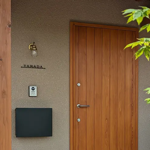 ベージュの壁に取り付けられた黒いステンレス表札