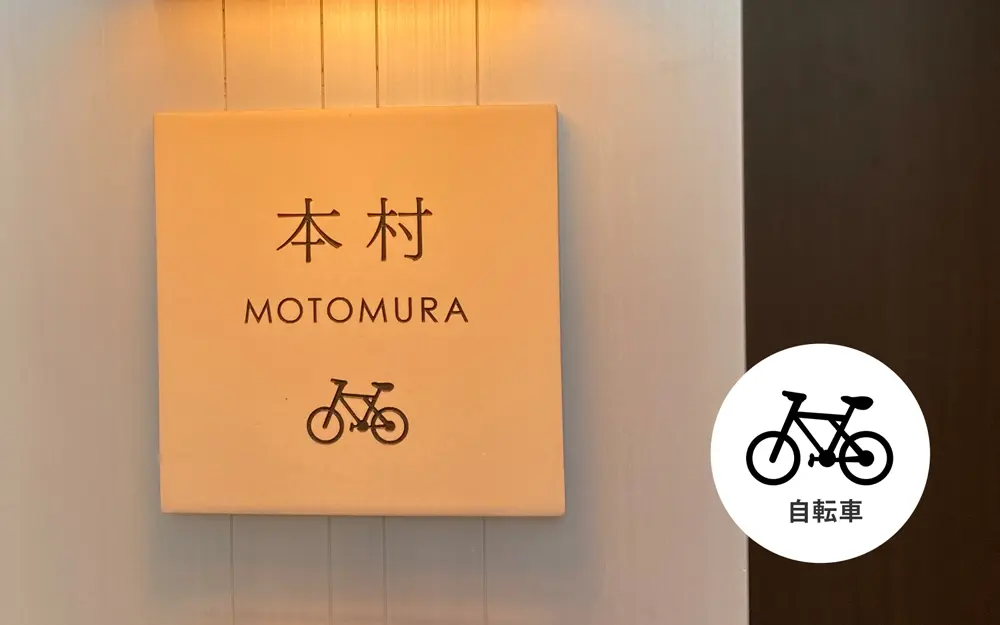 自転車モチーフのワンポイントがついたナチュラルアイボリーのタイル表札