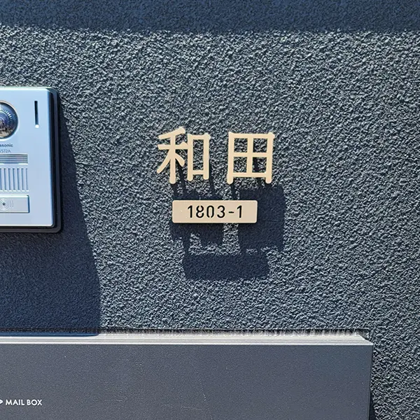 門塀に取り付けられたゴールドのステンレス表札
