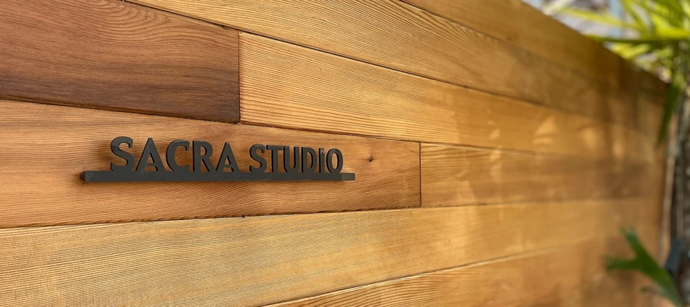 木目の壁に設置された黒い切文字のショップ看板