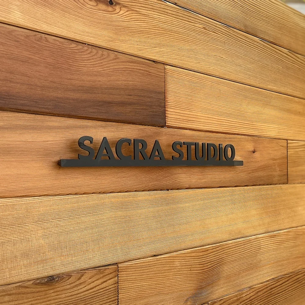 木目の壁に設置された黒い切文字のショップ看板