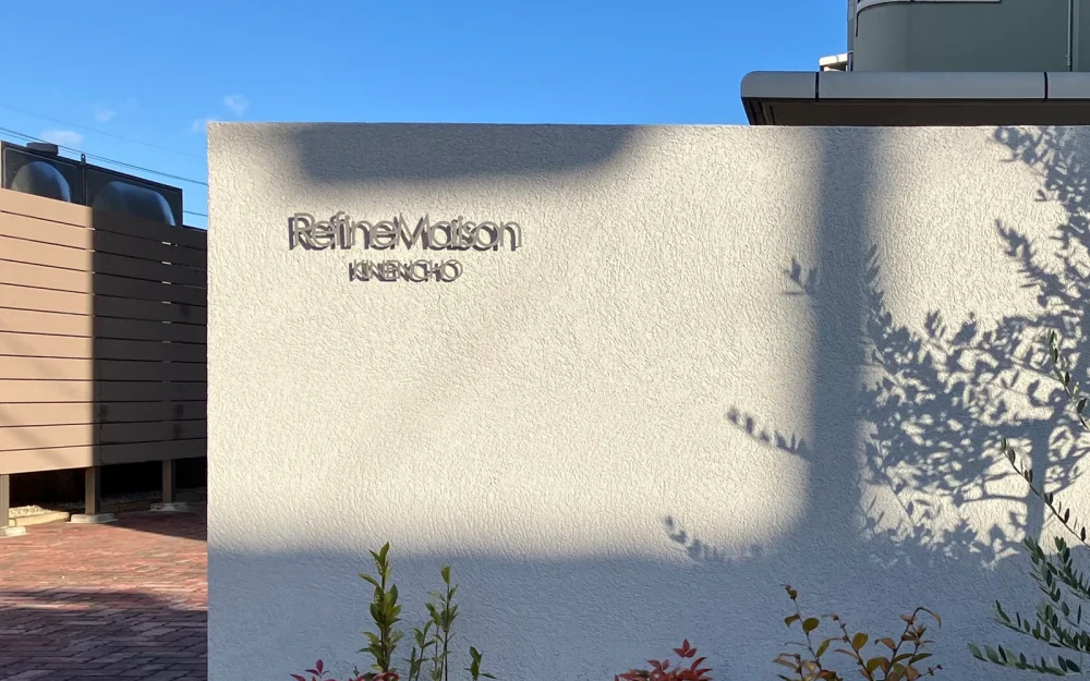 マンションのエントランスに取付けられたシルバーのステンレス切文字看板