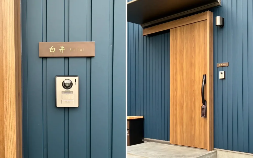 ブルー系の壁にブラウンのタイル表札を付けている家。