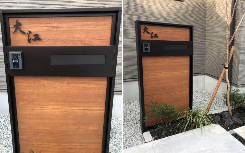 木目の機能門柱にブラックの独立型の切り文字ステンレス表札を付けている家。