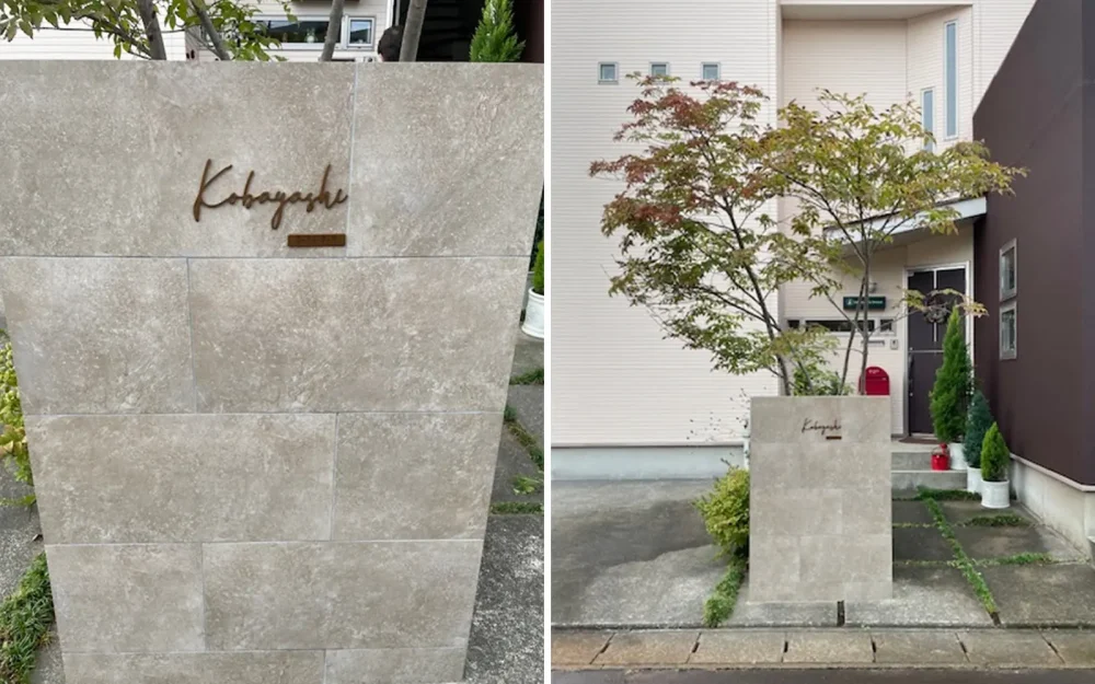 ベージュの門柱にブラウンのステンレス表札を付けている家。