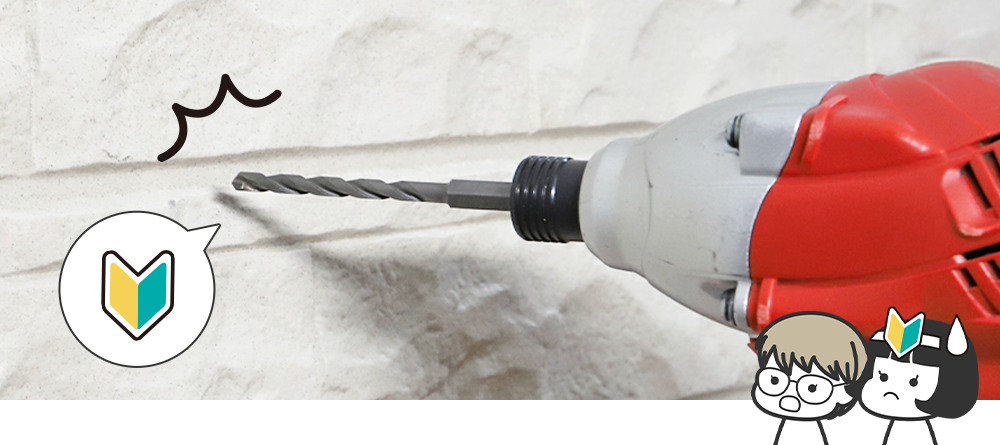 初心者マークのついた壁に表札取付けのための穴を開けようとしているドリルの画像と、右下に驚いた顔のハマダ先輩と初心者マークを頭につけた新人イケダ