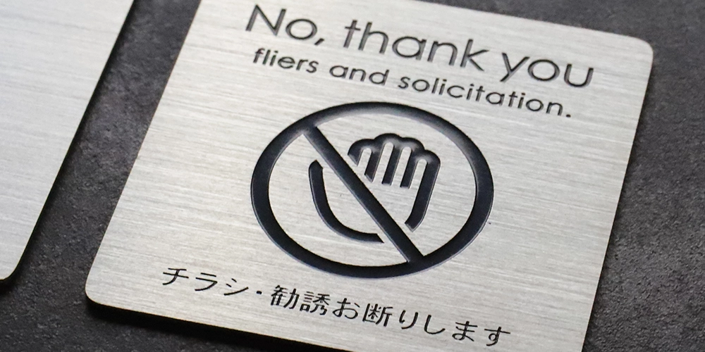 チラシお断りポストプレートのアップ画像。表札にも使われるSUS304(ステンレス)を用い、印刷ではないエッチング加工を施しています