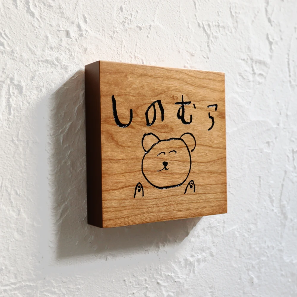 手書きのイラストと文字を彫刻した表札